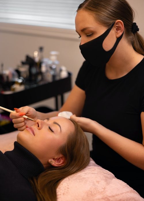 Eyelash extension procedure with master and a client in a beauty salon